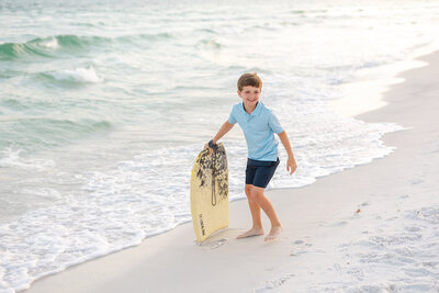 boy with skim board on 30a beach