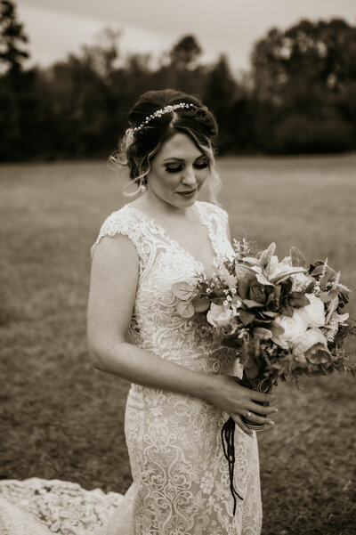 little rock ar bride ina. lace wedding dress and boho headpiece while holding a lush bridal bouquet