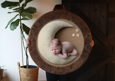 wood framed photoblock of newborn with moon prop