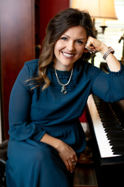 Amy canchola sits in her vocal studio at the piano