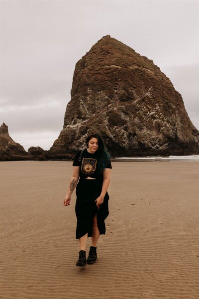 Portrait of woman walking along Cannon Beach in front of Haystack Rock, Oregon