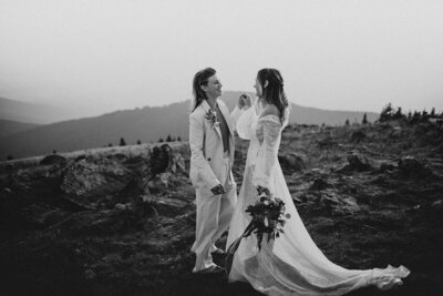 black and white image of lgbtq couple dancing on mountain