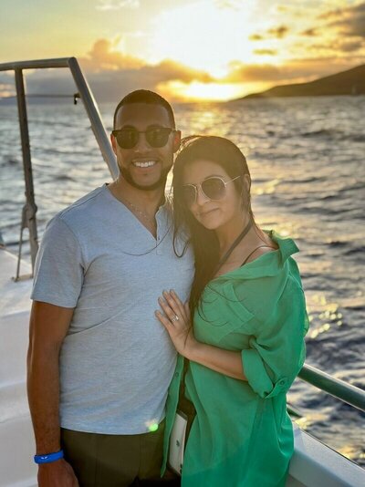 Photo of couple on a boat at sunset with personal vacation planner for destination weddings