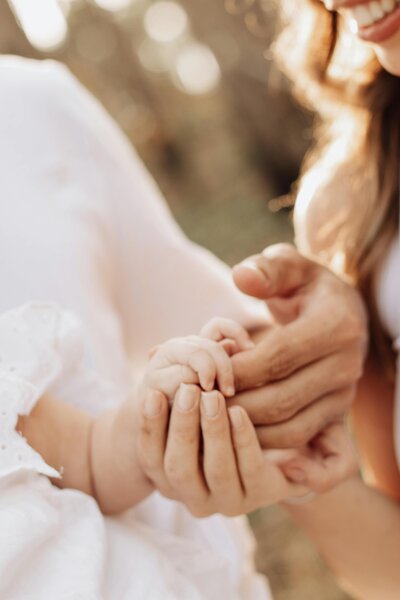 Adult and child hands clasped together | Rooted Within parent guidance and family evaluations