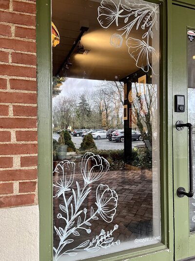 Hand drawn spring flowers  on storefront windows of Cheshire, Connecticut business