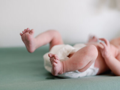Close-up of tiny newborn feet nestled in a soft blanket, representing the tenderness of new life.