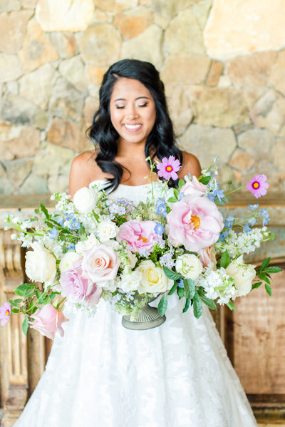Close up of bride's bouquet with pink roses, greenery, and baby's breath