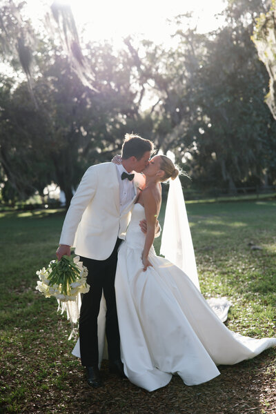 Bride and groom run down the street at golden hour