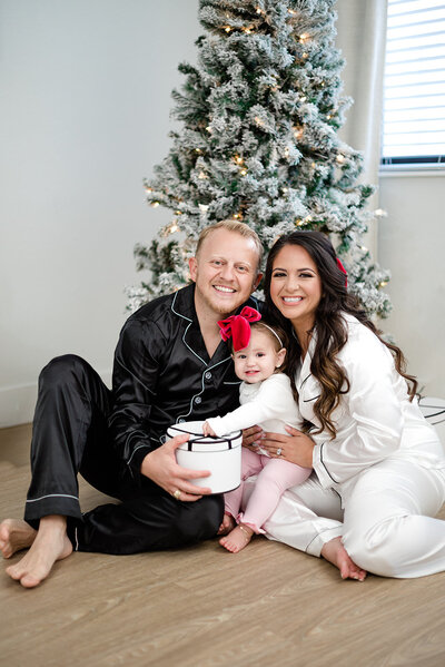 Family of three in front of the Christmas tree by miami christmas mini session photographer msp