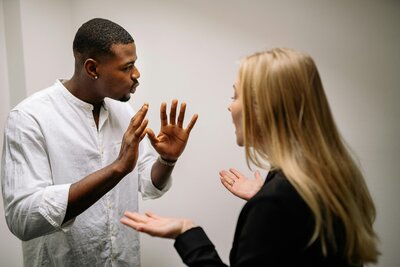 A black man and a white blonde woman argue at work