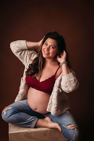 An easy-going, free-spirited, expecting mother poses for a maternity photo with Mobile, AL Maternity Photographer to showcase her