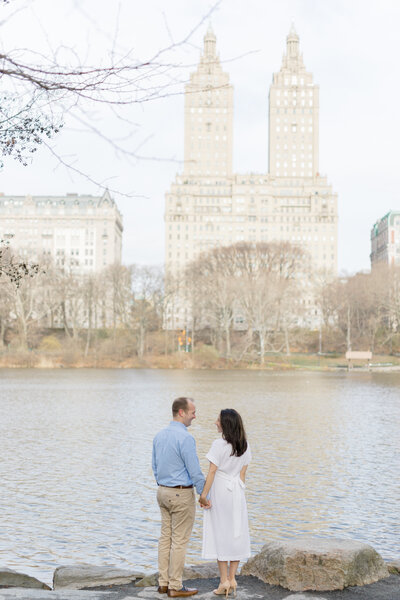 Couple in NYC looking over water for maternity photos