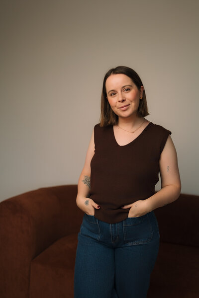 Liv Rollings sitting on rust colored couch