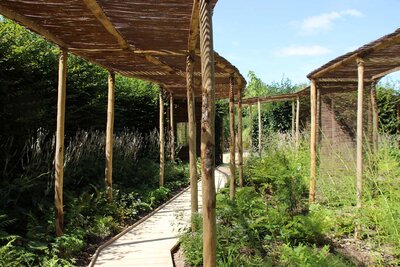 Jardin aménagé avec chemins en bois et couvre-soleil