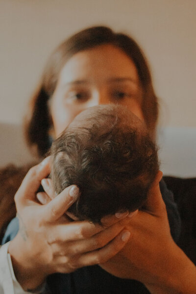 Close-up of a parent holding a newborn's head