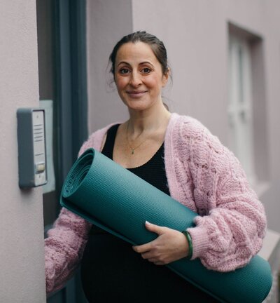 Mariella holding her yoga mat
