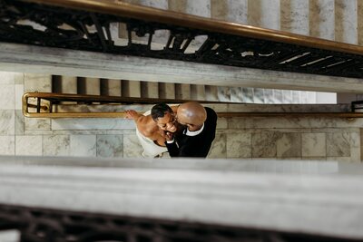 Louisville wedding photographer captures romantic newlyweds on marble staircase at Louisville Free Public Library.
