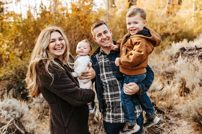 Family of four standing together in the warm fall glow of Reno.