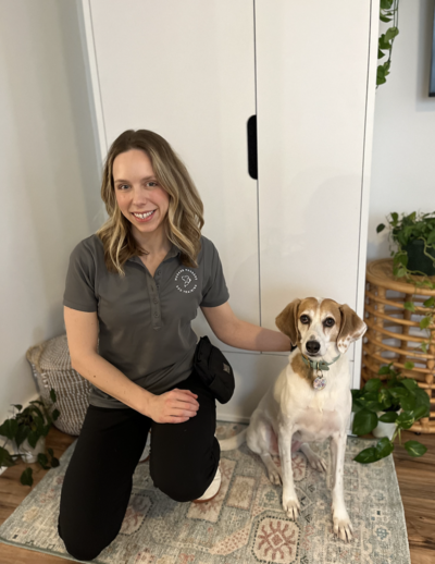 Dog trainer Michelle Pennarola sitting with a brown and white dog