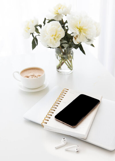 desktop with phone and notepad on top
