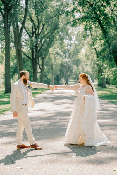 a bride and groom dance at Riverside Park with a Grand Rapids wedding photographer