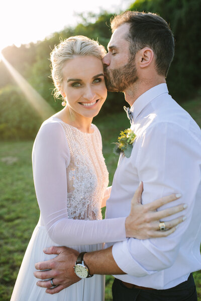 Intimate moment of couple gazing into each other’s eyes, bathed in warm, golden light from the setting sun.
