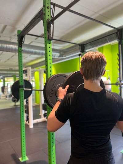pt max söderlund laittamassa painoja kyykytankoon salilla