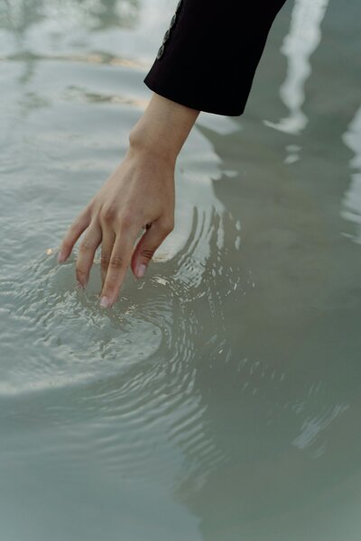 hand skimming the surface of water