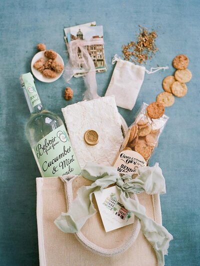 Jute tote wedding welcome bag with local snacks, vintage postcards and a watercolor tag of Charleston