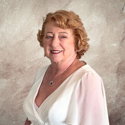 Elegant older bride with short vintage curls and soft glam makeup in a classic white gown, styled by Your Girl Friday LV in Las Vegas.