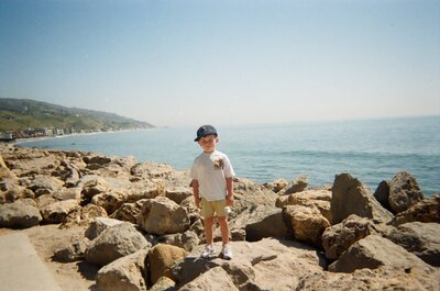memories on film of little boy standing on the rocks on the malibu coast