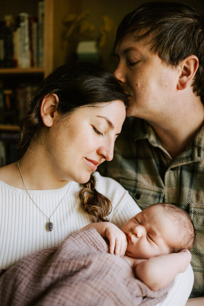 mom touching baby's nose as dad watches during session with Portland newborn photographer