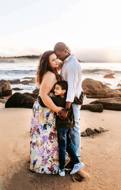 Morgen's family standing on the beach at sunset