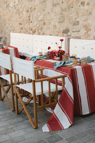 Blue and white toile off the shoulder dress next to a sage green suit jacket for an Italian themed wedding Welcome Dinner in the Provencal village of Gordes, France