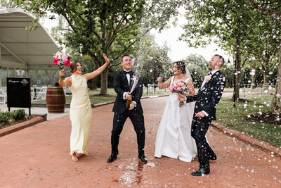 Bride and groom spray champagne with their bridal party at Sunnybrae Estate