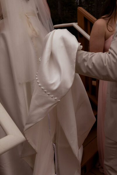Groom gently holding the bride’s dress during a Utah wedding, photographed by Lamblight Photography