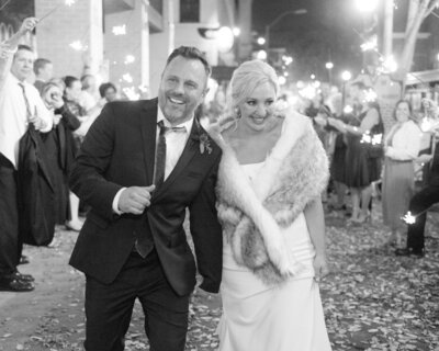 Couple just got married and is leaving their reception with a sparkler send off from their family.