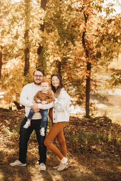 A small family cuddles together amongst the fall foliage in Brommelsiek park in O'fallon Missouri.