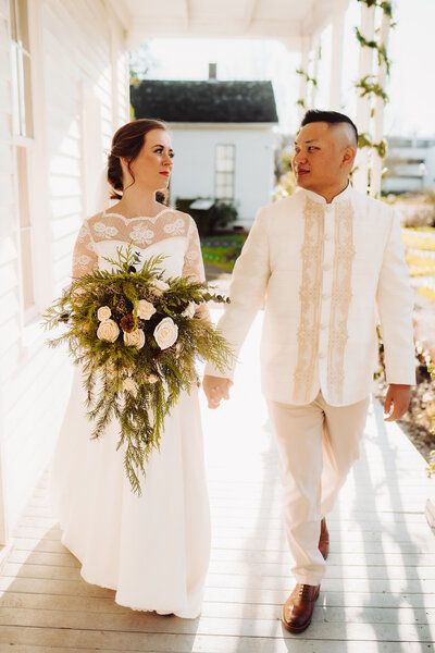 Wedding Photographer Service, couple walking hand and hand along house porch