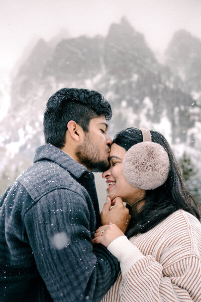 Couple kissing in snow by Denver Engagement Photographer