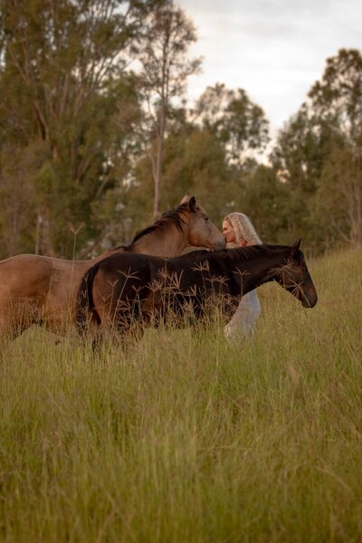 Coaching with horses in Australia – woman bonding with a horse through The Goddess Within's somatic mentorship.