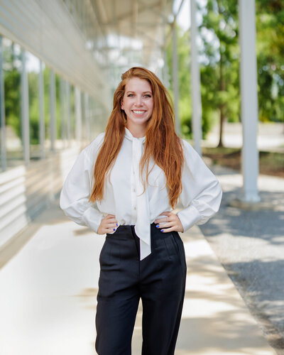 a redheaded woman in a white blouse