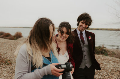 bride and groom looking at photographer's camera