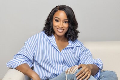 Alisha sitting on a couch smiling