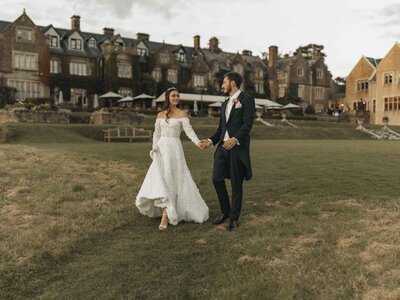 Bride and groom holding hands at sunset