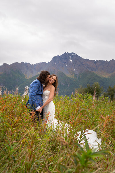 Newly weds dance in the tall meadow grass in th Alaskan mountains.