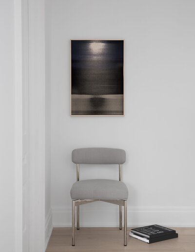 Contemporary art hung above a modern accent chair