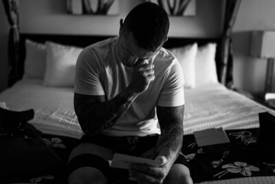 Luxury Portraits by Moving Mountains Photography in NC - Black and white photo of a groom crying while reading the brides letter