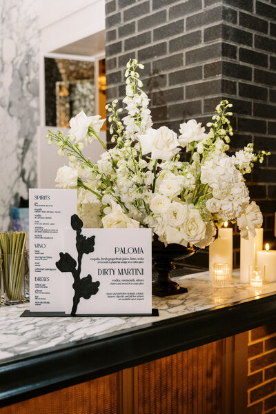 A black and white custom wedding invitation suite featuring a debossed invitation with wedding rings on it and a details and RSVP card by alyssa amez design custom wedding stationery and signage designer against a white background.