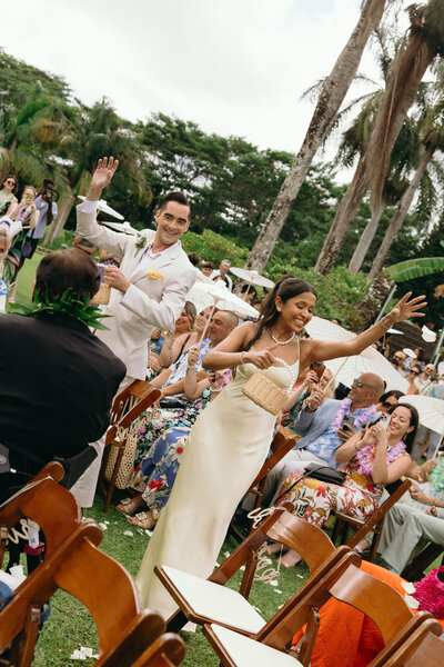Bride and groom popping champagne on a cliffside at sunset in Maui
